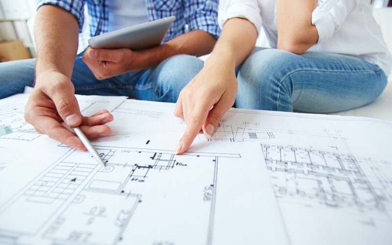 Discussing scheme Hands of young couple during discussion of plan of flat